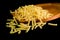 Close up yellow uncooked raw Fusilli pasta noodle on wooden board and black background