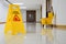 Close up yellow warning sign with message Cleaning in progress with cleaning trolley background