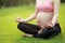 Close-up yoga gesture pregnant woman sit in meditation on grass meadows on sunny sunshine sunset sunrise nature outdoor