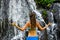 Close up of yoga woman in front of waterfall. Hands in gyan mudra. View from back. Pucak Manik waterfall Wanagiri, Bali, Indonesia