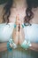 close up of yoga woman hands in namaste gesture with lot of boho style jewelry rings and bracelets outdoor