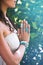 close up of yoga woman hands in namaste gesture with lot of boho style jewelry rings and bracelets outdoor