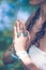 close up of yoga woman hands in namaste gesture with lot of boho style jewelry rings and bracelets outdoor