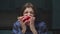 Close up of young 20s man hungry eating red paprika in funny way on the kitchen. Funny eating.