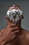 Close up of young african american man with foam applied on his face using steel razor for removing stubble from neck