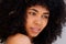 Close up young african american woman with curly hair looking away