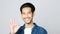 Close up of young asian man showing ok hand sign and smiling while standing over isolated yellow background, Happy asia male