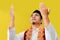 Close-up of a young Asian Muslim man praying raising his hands wearing Muslim dress, low angle and close-up