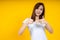 Close up of young Asian woman isolated on yellow background showing thumps up