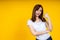 Close up of young Asian woman isolated on yellow background showing thumps up