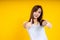 Close up of young Asian woman isolated on yellow background showing thumps up