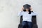 Close up of young asian woman reading book and hiding face on cement background