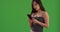 Close up of young asian woman using cellphone to send texts on greenscreen