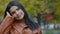 Close-up young attractive elegant pensive dreamy woman standing in autumn park portrait hispanic girl model posing