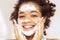 Close up of young beautiful darkskinned woman cleaning her skin with facial wash