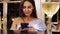 Close-up of young beautiful girl browsing smartphone sitting at the bar.