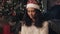 Close Up of Young Beautiful Mulatto Girl in Santas Hat Sitting under Decorated Cristmas Tree Preparing Presents, Packing