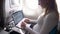 CLOSE UP: Young Caucasian businesswoman works on her computer during her flight.