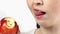 Close up of young Caucasian woman with braces eating apple and shows apple with lost brackets locks. Concept of