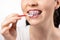 Close up of young Caucasian woman with brackets on teeth cleaning interdental space using orthodontic toothbrushes