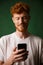 Close-up of young cheerful redhead bearded young man, listening