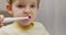 Close-up of a young child using an electric toothbrush, focusing on oral hygiene