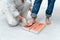 Close up of a young chiropodist in her clinic examining a patient`s feet in the foam for insoles.