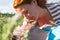 Close-up of a young couple romancing outdoor. Close up faces of attractive couple, they watch each other in the green grass