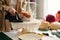 Close-up of young craftswoman with electric appliance ironing new hat