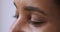 Close up of young ethnic female brown eyes looking aside