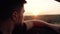 Close-up of a young European man driving a car at sunset. Serious man watching the sunset from the wheel of the car he