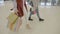 Close up of young fashion addict girls wearing heels marching in the mall to do weekend shopping -