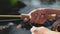 Close up of a young female asian hand stripping fly fishing line on a river