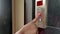 Close up of Young female hand pushing / pressing elevator / lift button up in Office Center or Hotel or home apartment