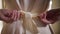 Close-up of young female hands tying bow on elegant beige dress. Stylish Caucasian woman trying on outfit in fashion