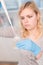 Close up of Young female scientist working in genetics laboratory with pipette in white biological sample