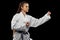 Close-up young female taekwondo athlete training isolated over dark background. Concept of sport, education, skills