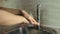 Close-up of a young female washing his hands thoroughly in the kitchen.