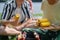 Close-up of young friends putting corn on grill and having barbecue when camping in campground.