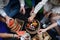 A close-up of young friends putting corn and skewers on grill and having barbecue when camping in campground.