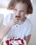 Close-up of Young girl with cake eating strawberry