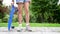 Close up young girl feet holding a blue skate in hands in the park