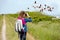 Close up of a young girl looking through binoculars at flamingos