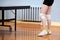 A close-up of a young girl`s legs is tied with white elastic bandages at the knees next to a tennis table in the gym