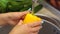 Close-up of a young girl washing yellow bell peppers at home in the kitchen. 4K