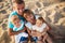 Close up of young happy loving family with small kids in the middle, having fun at beach together near the ocean, happy lifestyle