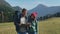 Close-up of young hipster family traveling in mountains of Europe. Guy holding paper map in hands, girl show correct