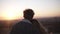 Close up of young long haired woman and man looking at the city at sunset standing on the roof of the high building