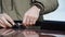 Close Up of a Young Male in Beige Parka Fastening Screws with a Ratchet Spanner on a Car Railing Rack