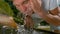 CLOSE UP: Young male cools off from summer heat by splashing water at his face.